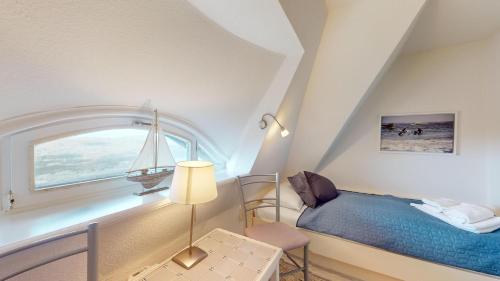a bedroom with a bed and a window with a sailboat at Haus Weststrand in Hörnum