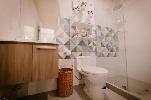 La salle de bains est pourvue de toilettes et d'une douche en verre. dans l'établissement Loft Javier Prado, à Lima