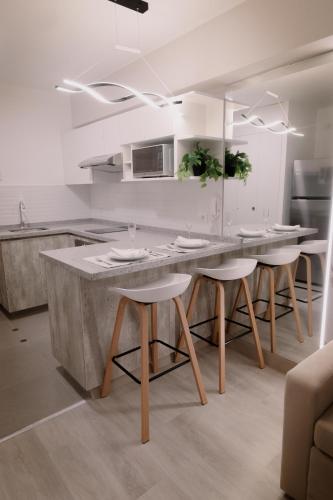 a kitchen with a large counter with stools in it at Loft Javier Prado in Lima