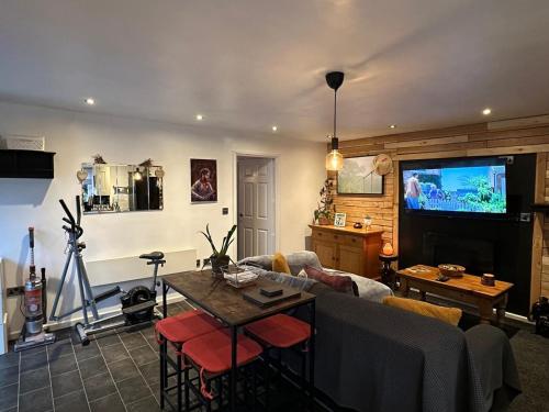 Shropshire Guesthouse في ولفرهامبتون: غرفة معيشة مع أريكة وتلفزيون
