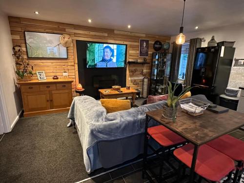 a living room with a couch and a tv at Shropshire Guesthouse in Wolverhampton