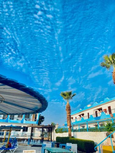 a pool at a resort with palm trees at Regency Hotel in Sharm El Sheikh