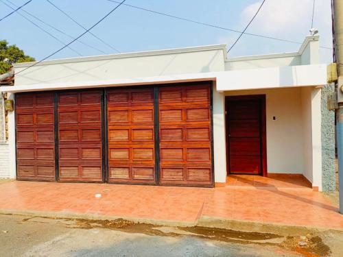 a garage with two wooden garage doors on a house at Linda Vista Hostal in Managua