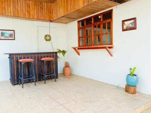 a room with two stools and a counter in a building at Linda Vista Hostal in Managua