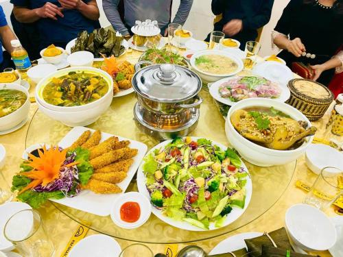una mesa cubierta con platos de comida y tazones de comida en KHÁCH SẠN KIM NHAN, en Anh Sơn