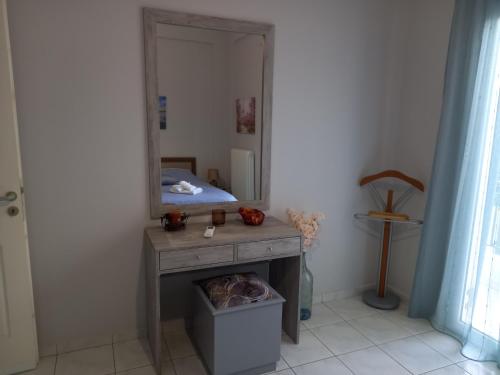 a room with a vanity with a mirror and a bed at Σπίτι δίπλα στην θάλασσα in Patra