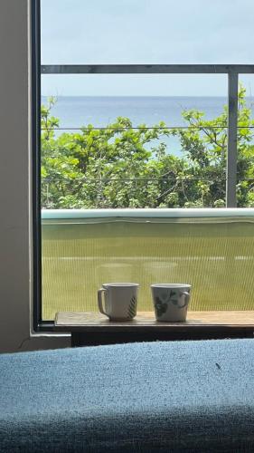 two bowls sitting on a table in front of a window at 永勝客棧 in Manzhou