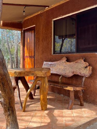 a wooden bench in front of a house at La Montaña Parque Natural in La Curva
