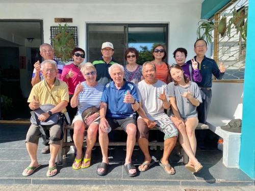 a group of people posing for a picture on a bench at 永勝客棧 in Manzhou
