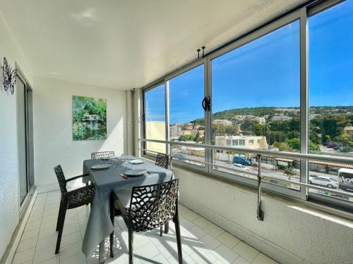 - une salle à manger avec une table, des chaises et de grandes fenêtres dans l'établissement Joli studio-cabine moderne à 300m de la plage - FR-1-338-368, à Sète