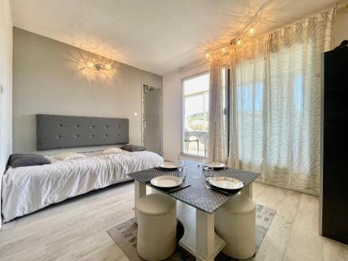 - une chambre avec un lit et une table avec des plaques de cuisson dans l'établissement Joli studio-cabine moderne à 300m de la plage - FR-1-338-368, à Sète