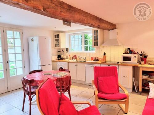 une cuisine avec une table et des chaises dans une pièce dans l'établissement Gîte cosy et rénové à Boissets avec jardin clos, WiFi, proche randonnées et sites touristiques. - FR-1-527-46, à Boissets