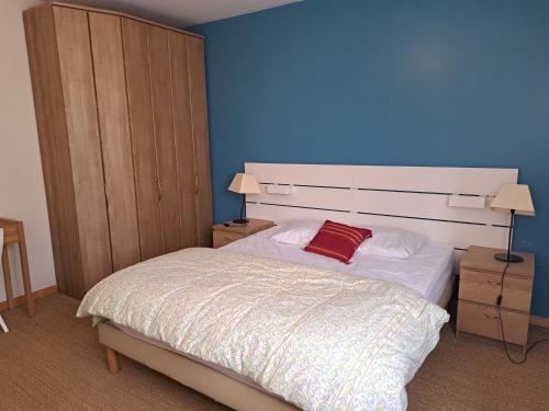 une chambre avec un lit avec un mur bleu dans l'établissement Appartement Confortable avec Balcon - Saint Jean de Monts - FR-1-323-532, à Saint-Jean-de-Monts