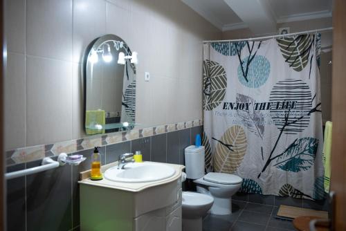 La salle de bains est pourvue d'un lavabo, de toilettes et d'un rideau de douche. dans l'établissement Casa Espaçosa perto de Angra, à Angra do Heroísmo