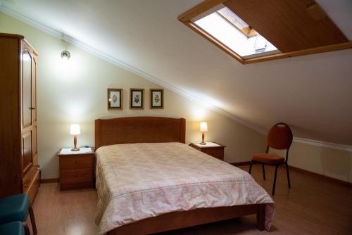a bedroom with a bed and a skylight at Casa Espaçosa perto de Angra in Angra do Heroísmo