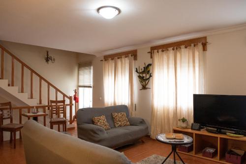 a living room with a couch and a flat screen tv at Casa Espaçosa em Angra do Heroísmo - Ilha Terceira in Angra do Heroísmo