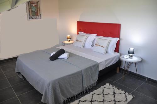 a bedroom with a large bed with a red headboard at L'EDEN DE JOSEPHINE in Le Moule