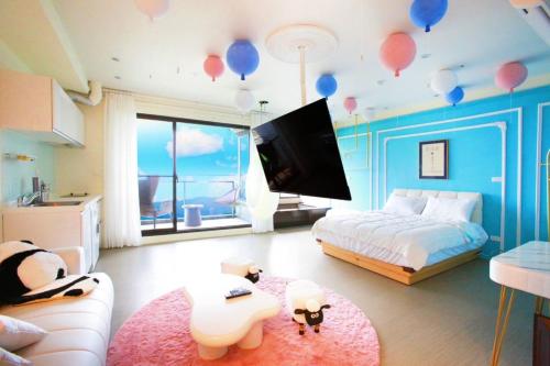 a bedroom with a bed with balloons on the ceiling at 光嶼海溫泉海景無邊際泳池豪華套房 in Hsin-hsing