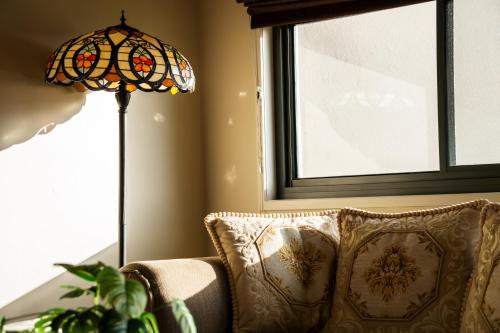 a lamp sitting next to a couch next to a window at Yarra Valley Serenity House in Golf Course Resort in Wonga Park