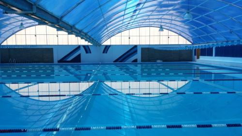 a large swimming pool with a blue ceiling at Hotel Paraiso Inn in Tehuacán