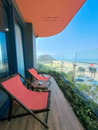 a balcony with two chairs and a view of the beach at Flamingo Hải Tiến - Căn góc 2 Phòng - View 2 mặt biển in Thanh Hóa