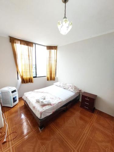 1 dormitorio con 1 cama y TV. en Departamentos de la Costa en Machala