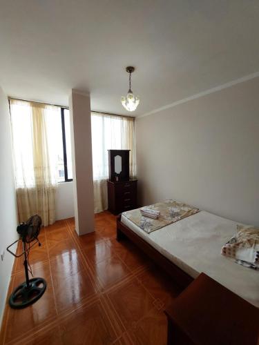 a bedroom with a bed in a room with wooden floors at Departamentos de la Costa in Machala