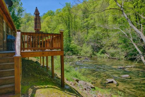 a deck overlooking a river next to a house at Historic Tapoco Lodge Resort in Tapoco