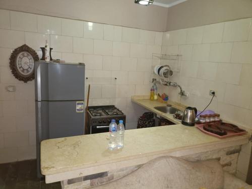 a small kitchen with a refrigerator and a counter top at شاليه سياحي مكيف صف أول علي البحر مباشره ومكيف وبحديقه خاصه in Ras Sedr