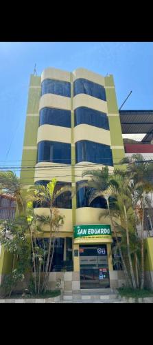 un grand bâtiment avec un panneau blanc san devant lui dans l'établissement Hotel San Eduardo, à Chiclayo