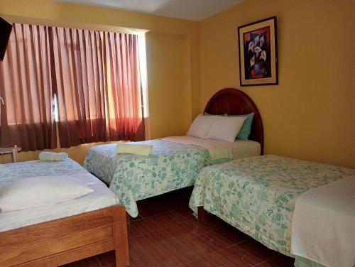 Hotel San Eduardo في تشيكلايو: غرفة فندقية بسريرين ونافذة