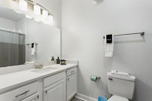 a bathroom with a sink and a toilet and a mirror at Royale Blue in Kissimmee