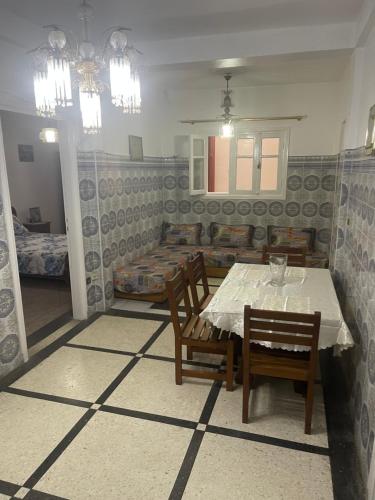 a dining room with a table and chairs and a bedroom at Appartement Casablanca in Casablanca