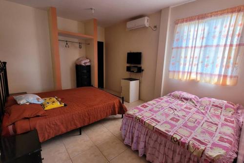 um quarto com 2 camas e uma janela em EVA Beach House em Crucita
