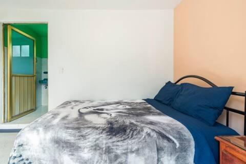 a bedroom with a bed with blue pillows at InkaNook Apartments in Cusco