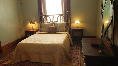 een slaapkamer met een groot bed en een raam bij The Eleanor Davis House in Hannibal