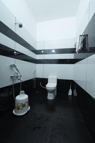 a black and white bathroom with a toilet and a shower at VILLA MANTRAA in Varkala