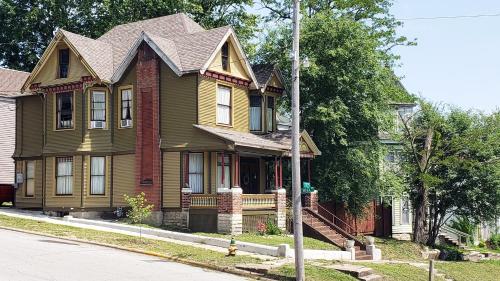 a green house with a roof on a street at The Eleanor Davis House in Hannibal
