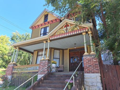 a small yellow house with a porch and stairs at The Eleanor Davis House in Hannibal