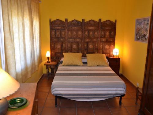 Schlafzimmer mit einem Bett mit einem großen Kopfteil aus Holz in der Unterkunft Apartamento en Primera Línea Playa con Piscina y Vista al Mar - L'Estartit, Centro - ES-323-71 in Torroella de Montgrí