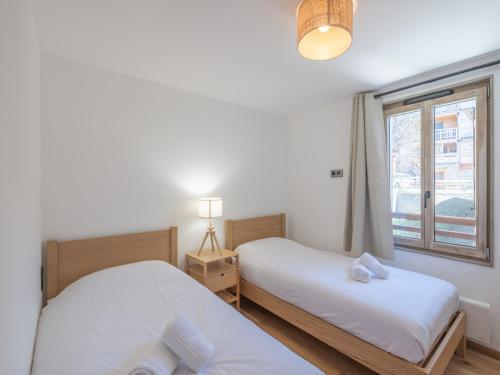 deux lits dans une chambre avec une fenêtre dans l'établissement Appartement neuf 65m² proche centre-ville - 400m des pistes, Wi-Fi - FR-1-645-72, à Huez