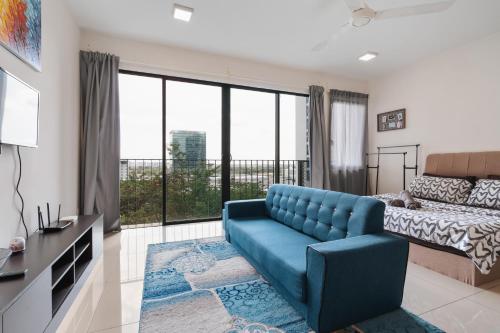 sala de estar con sofá azul y cama en NETFLIX STUDIO @ TREFOIL SETIA CITY en Setia Alam
