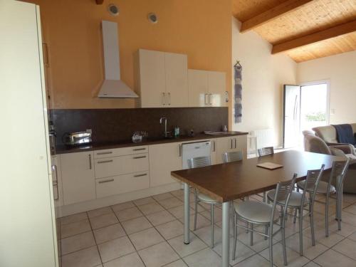 une cuisine avec une table et des chaises dans une pièce dans l'établissement Maison lumineuse avec jardin près de la plage - 2 chambres, animaux acceptés, WIFI, parking - FR-1-540-286, à Notre-Dame-de-Monts