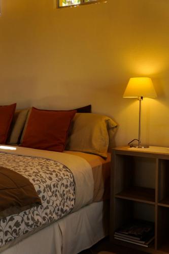 a bedroom with a bed and a lamp on a night stand at Quinta Estrella in Valle de Guadalupe