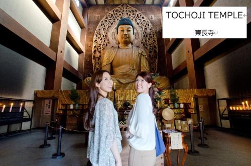 two women standing in front of a statue at belle lune hotel hakata Suite Room 1 in Fukuoka