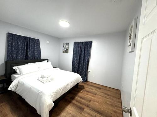 a bedroom with a white bed and blue curtains at Getaway at Falls-3 Beds-Slips 6 in Niagara Falls