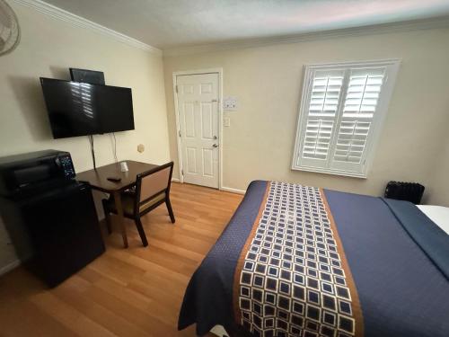 a bedroom with a bed and a desk and a television at Tamalpais Motel in Mill Valley