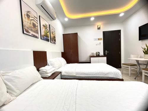Habitación de hotel con 2 camas y mesa en KAMI HOTEL en Phan Rang