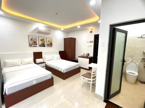 een hotelkamer met 2 bedden en een badkamer bij KAMI HOTEL in Phan Rang