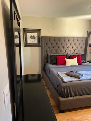 a bedroom with a large bed with red pillows at Vashay's Lovely vacation pad at Disney in Davenport